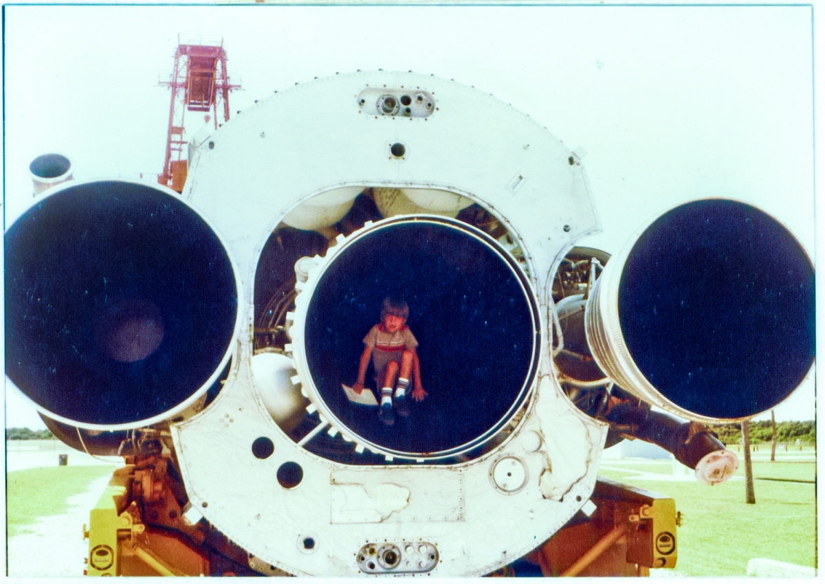 Kai MacLaren sitting deep inside of the nozzle of an Atlas ICBM (this is flight hardware and is not a replica) on display at Complex-26, Air Force Space Museum, Cape Canaveral, Florida. In the background, above and to the left, you can see part of the red gantry which serviced the Jupiter-C rocket which propelled the United States' first satellite into orbit on January 31, 1958, from this launch complex. Photo taken circa 1982.